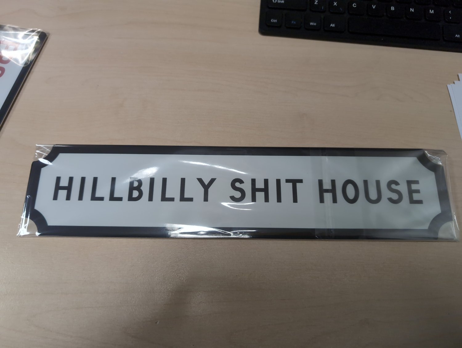 A sign that reads "hillbilly shithouse"